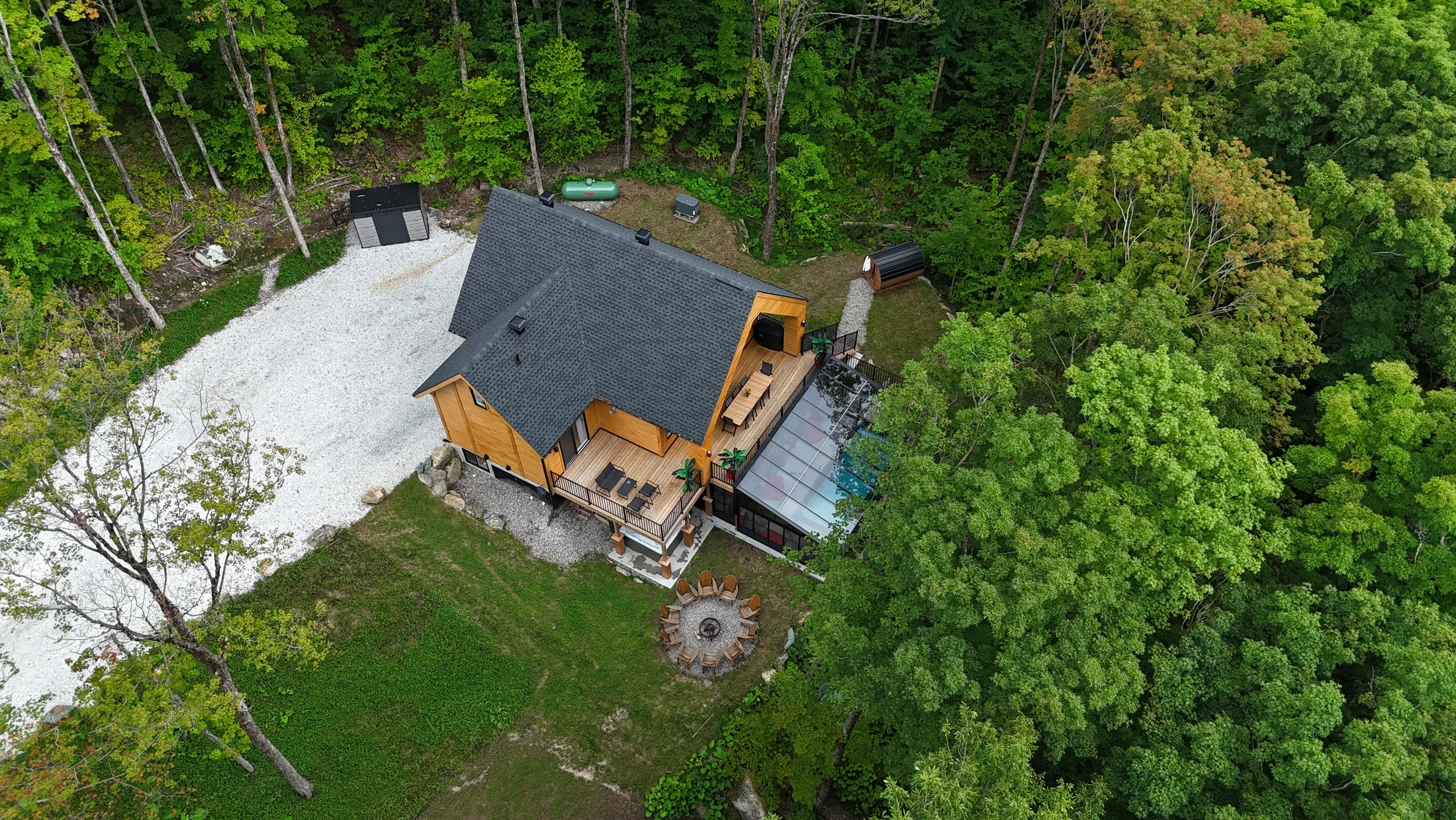 Vue aérienne rapprochée du chalet et de la forêt environnante