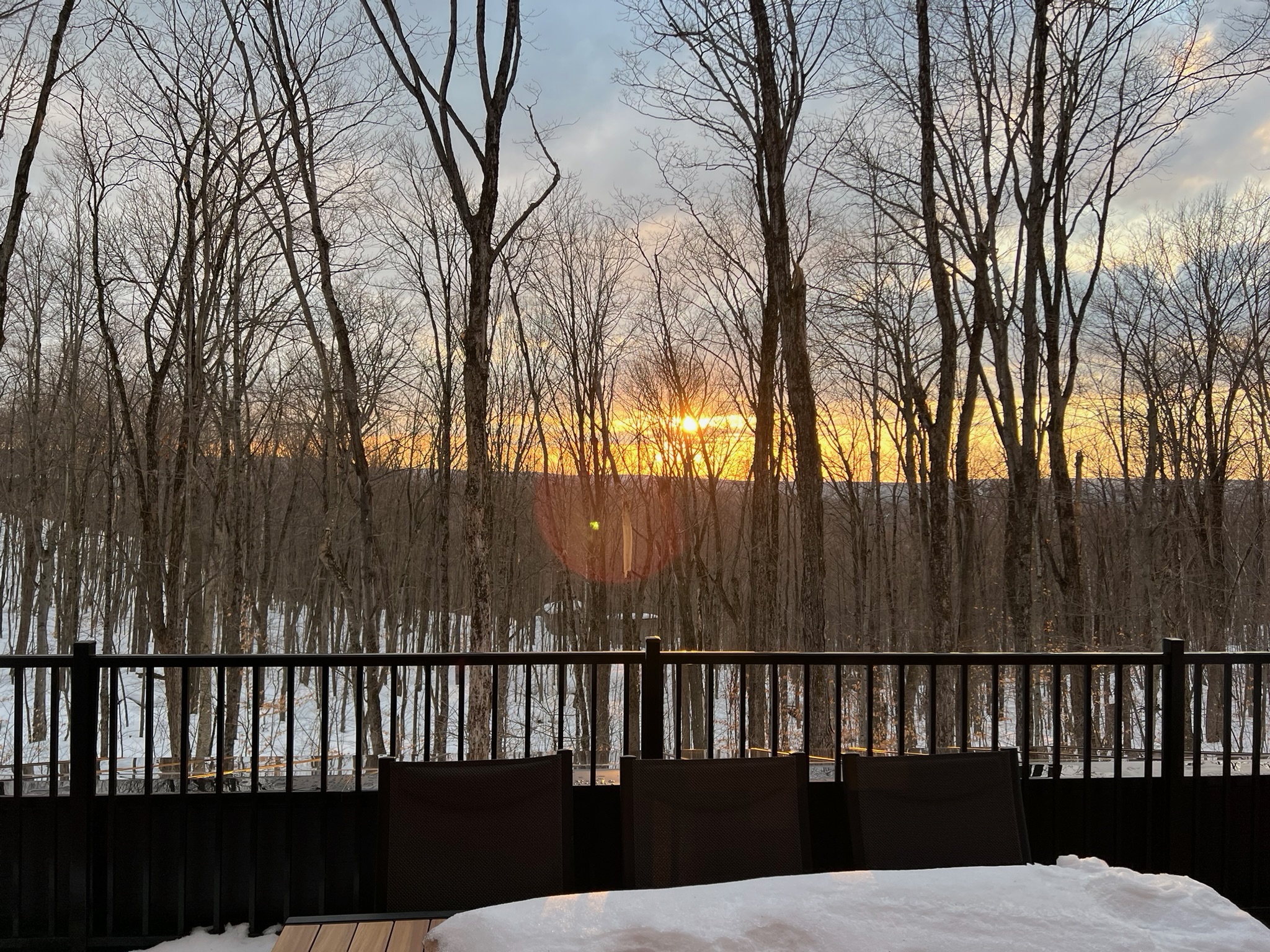 Le Havre des cimes dans la forêt enneigée au coucher du soleil