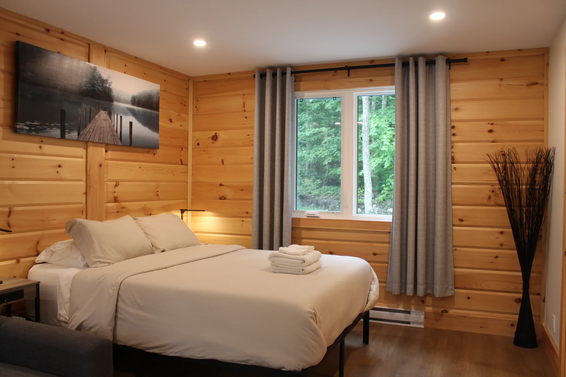 Chambre principale lumineuse avec vue sur la forêt en été