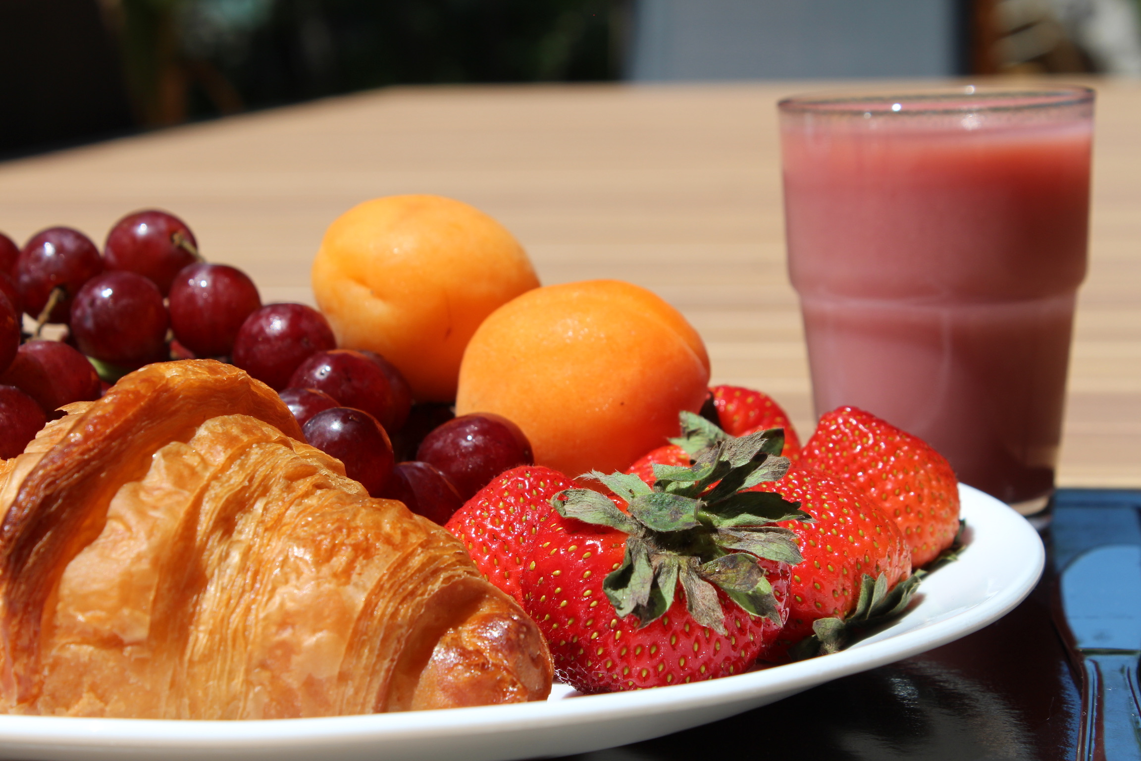 Déjeuner gourmand composé d’un croissant, de fruits frais et d’un jus