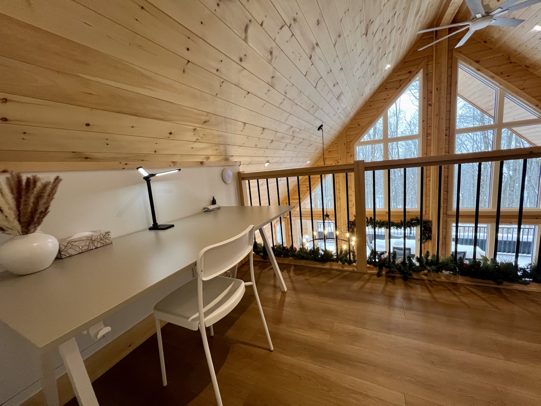 Espace de travail aménagé sur la mezzanine avec vue sur le plafond cathédrale