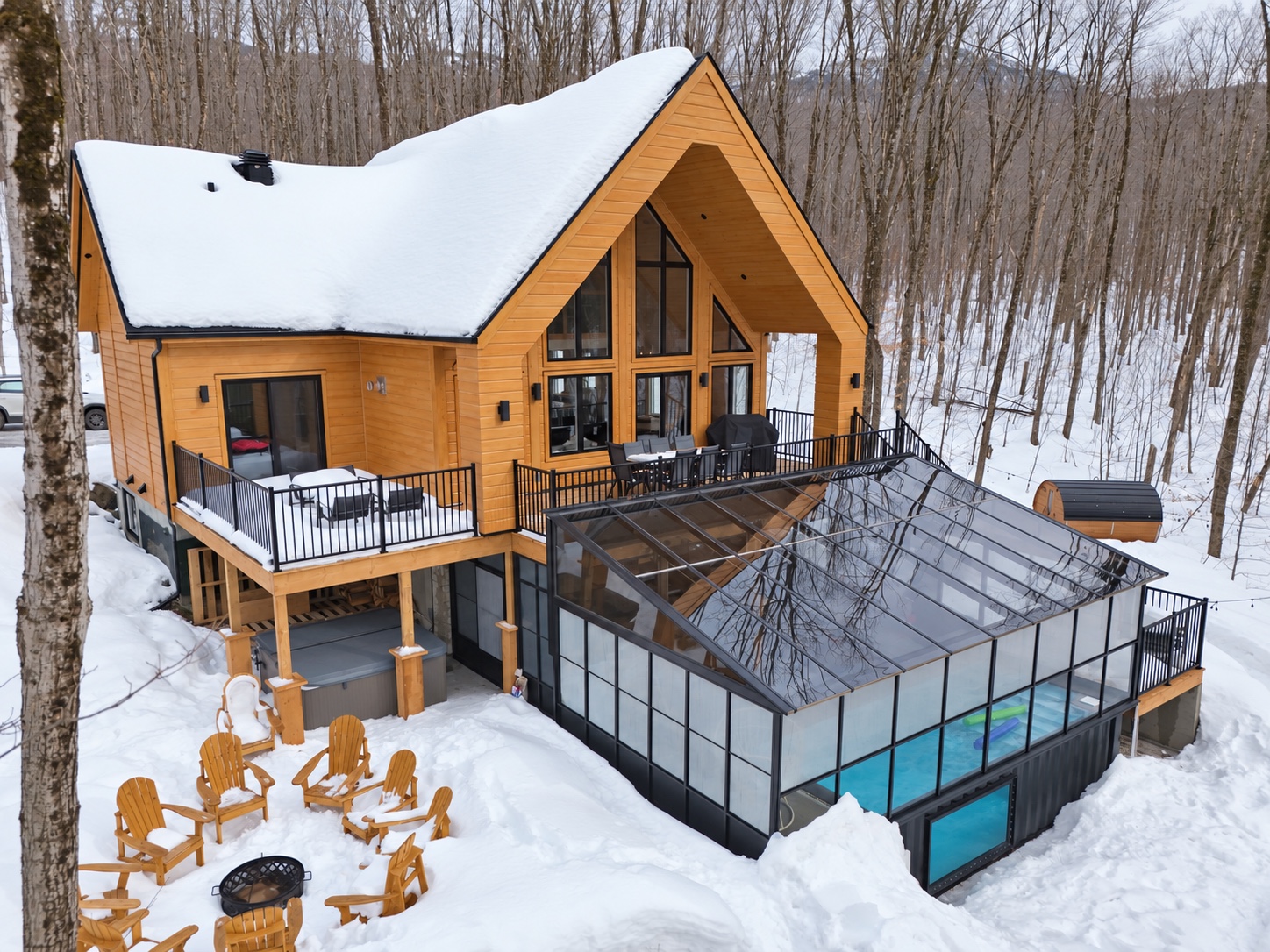 Vue aérienne hivernale du chalet, du solarium, de la piscine et du sauna dans la forêt